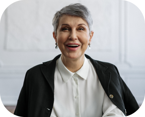 imagem de mulher sorridente e com boas vestimentas, que aparenta idade acima de 50 anos